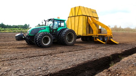 Traktor med sugvagn på torvtäkt.