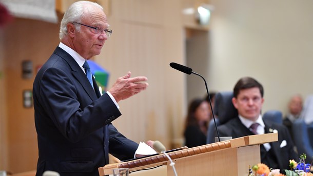 Kung Carl XVI Gustaf i plenisalen i samband med riksmötets öppnande 2019. Det är olämpligt att kungen öppnar riksmötet och håller tal till oss folkvalda, skriver debattörerna. 